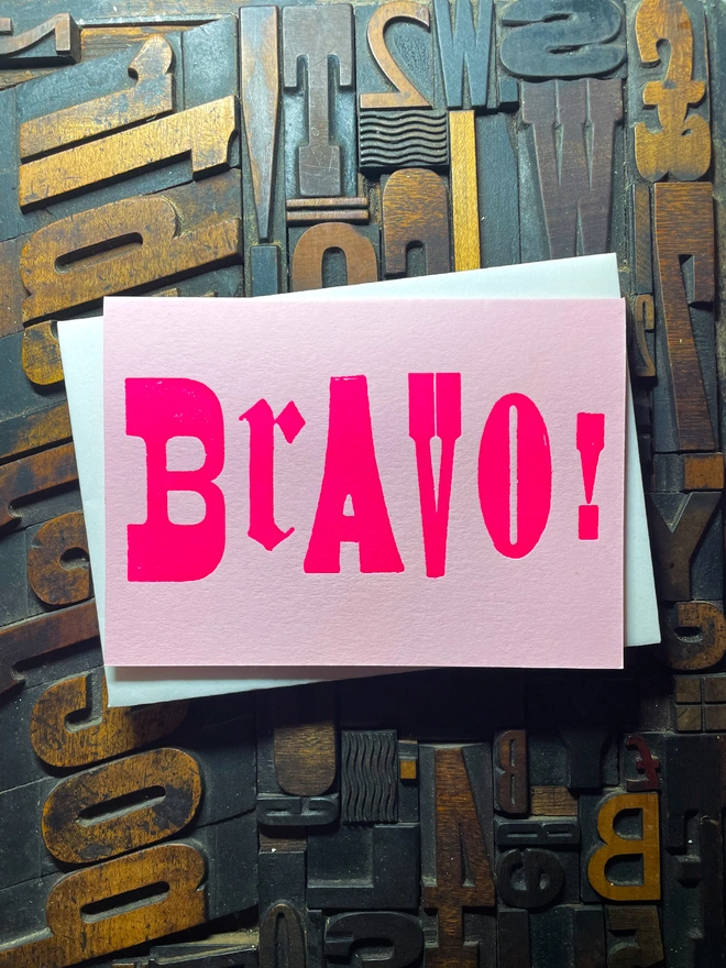 A congratulatory letterpress candy pink card featuring the deep impression word BRAVO!; in bold letters with a set of colourful envelopes. Perfect for exam results and graduations and other celebrations and milestones.