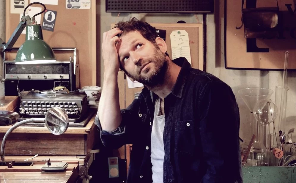 Andy Poplar, founder of Vinegar & Brown Paper, sitting at a desk clutching his hair and staring at the ceiling. 