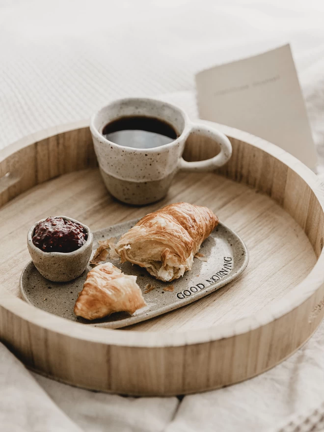 wooden tray holding an oval 'good Morning' plate beside a mug of coffee