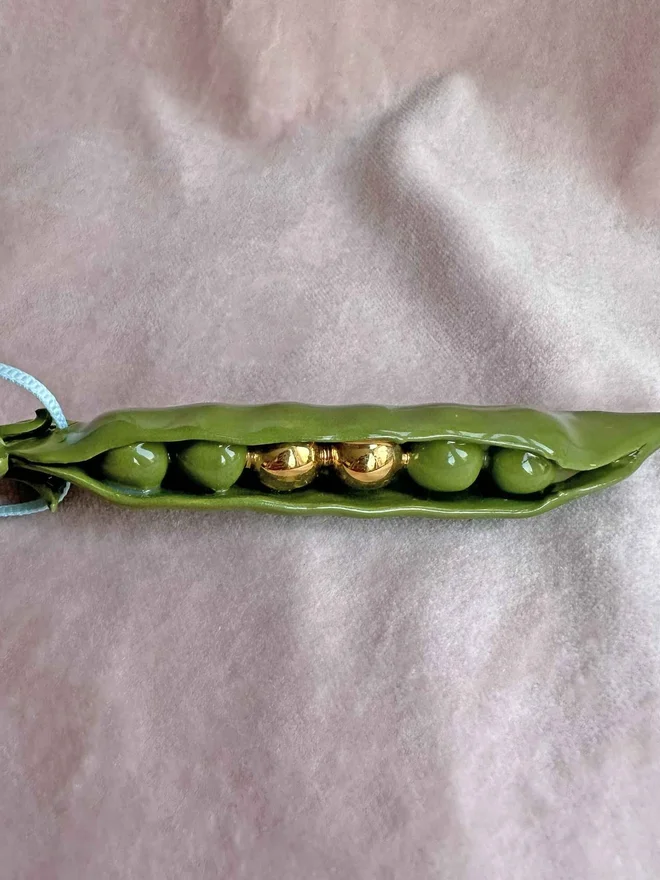 handmade ceramic peas in a pod christmas decoration with two gold peas