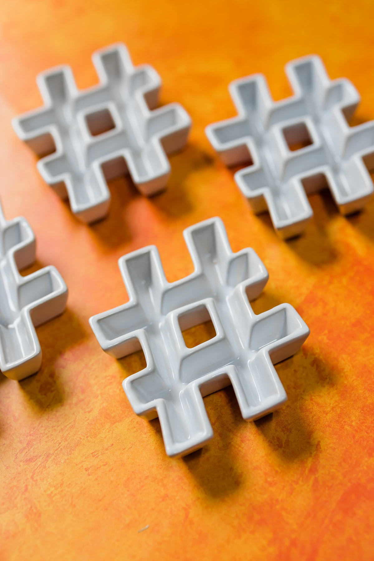 Ceramic hashtags seen on a wooden table.