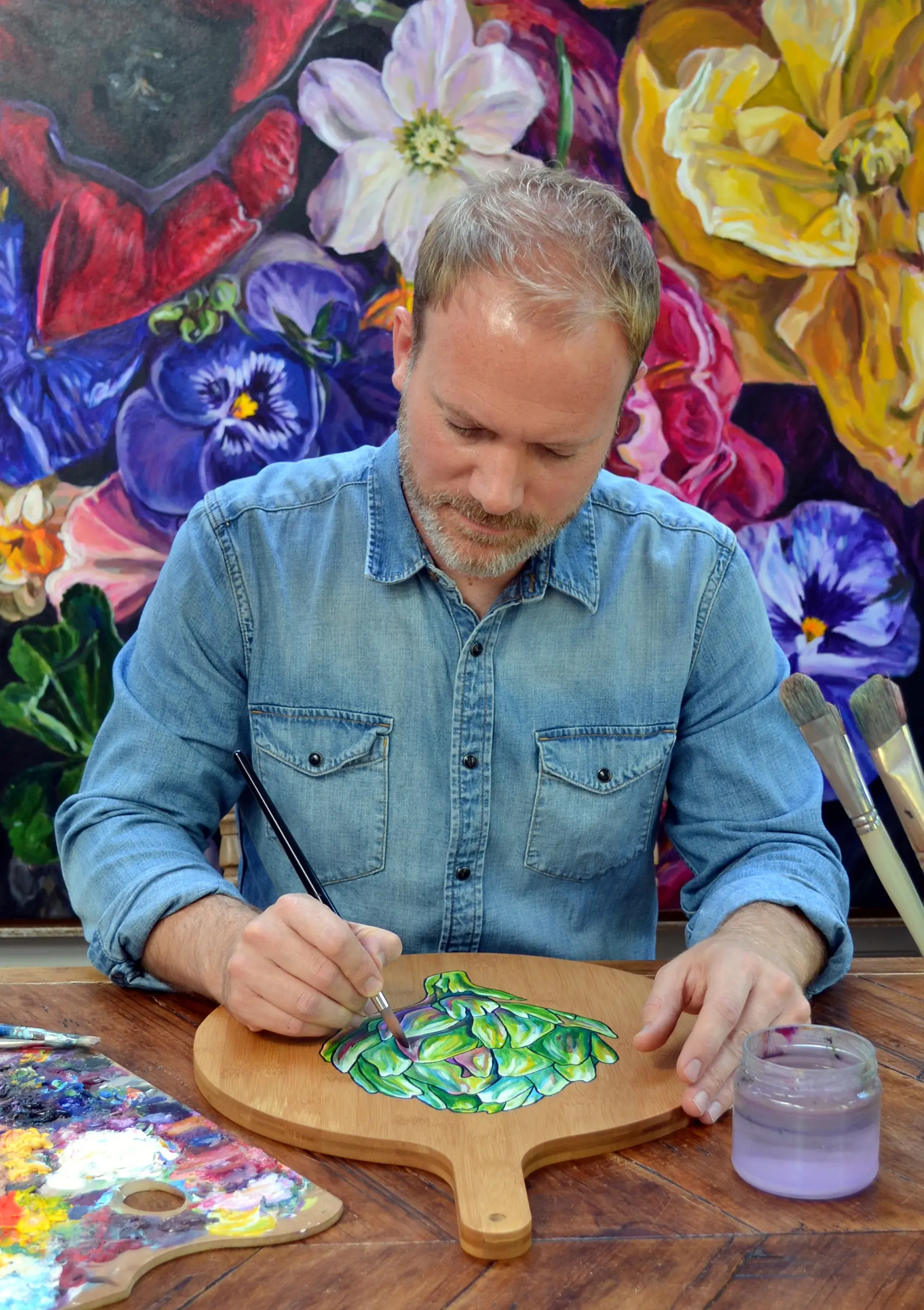 Alex Ebdon in his studio painting a wooden board