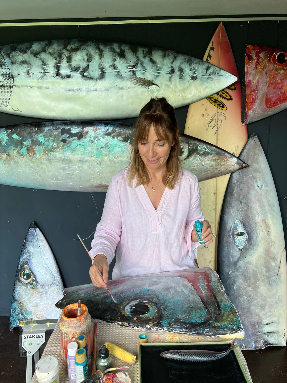 claudia painting fish in her studio