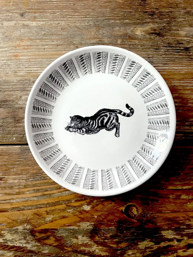 vintage plate with an ornate border, with a printed vintage illustration of a Victorian cat in the middle 