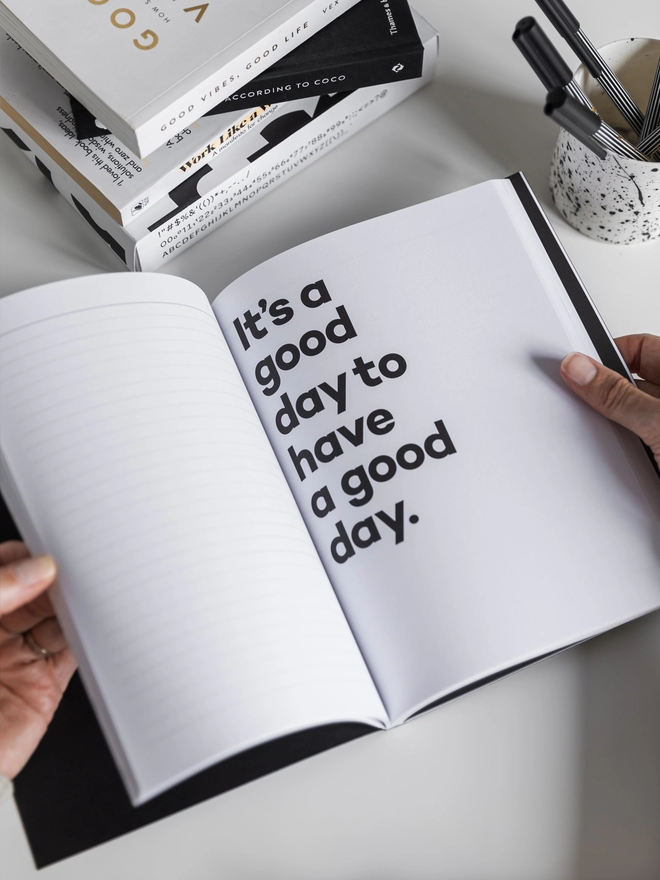 Lady holding a Hello Notes A5 Notebook on a quote page reading 'It's a good day to have a good day' 