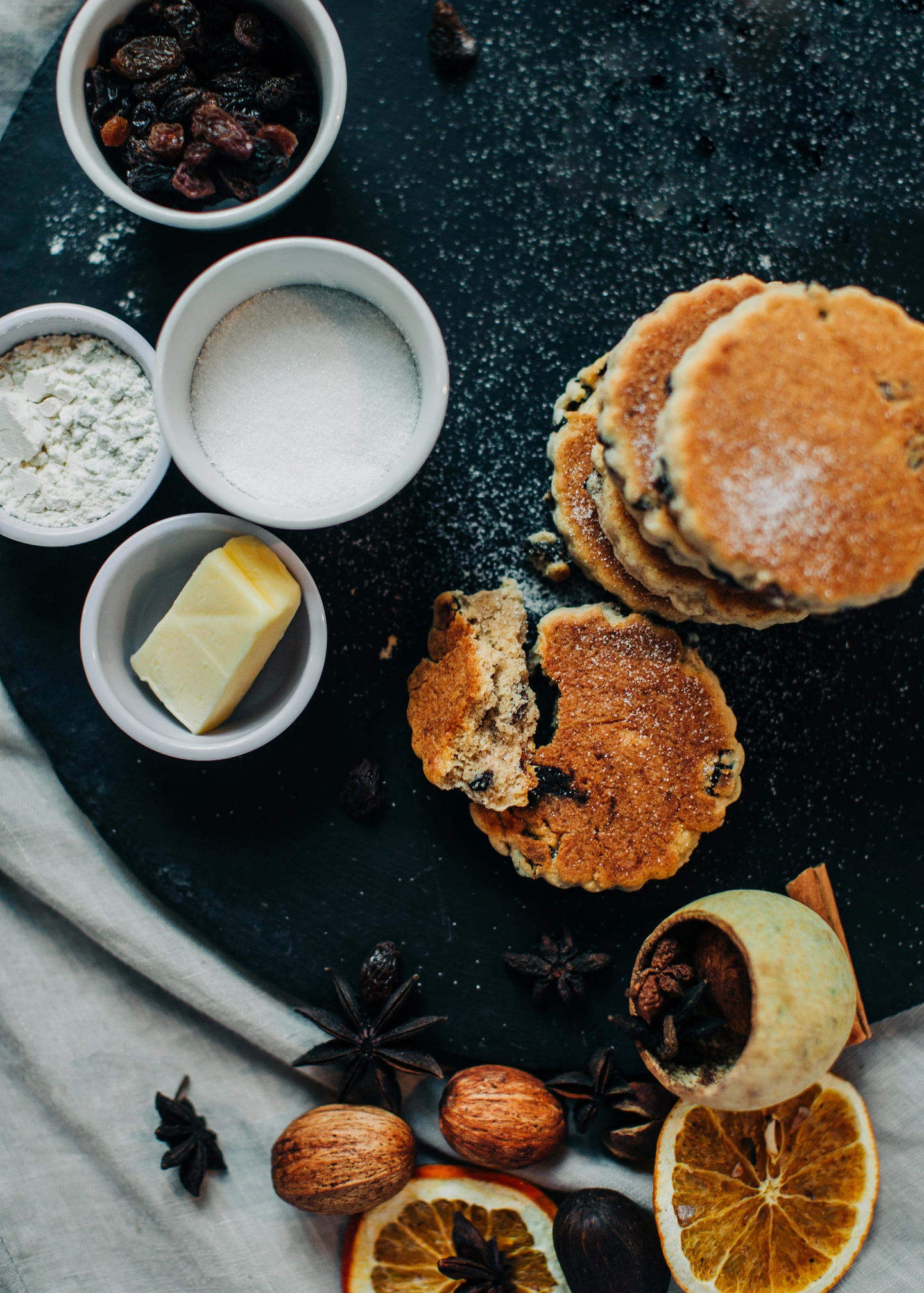Traditional Welsh Cakes displayed on a bakestone with the ingredients surrounding the welsh cakes