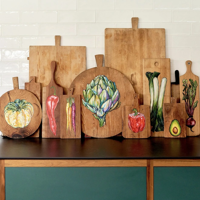 Hand painted chopping boards with vegetables in a kitchen