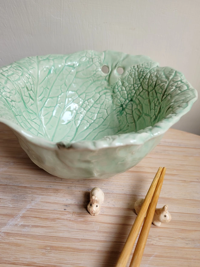 handmade ceramic noodle bowl with imprinted cabbage leaves design an holes for chopsticks with 2 ceramic chopsticks rest and chopsticks