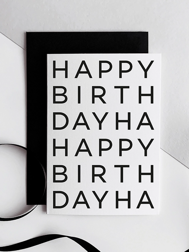 Happy Birthday Card laid on a black envelope on a white background.
