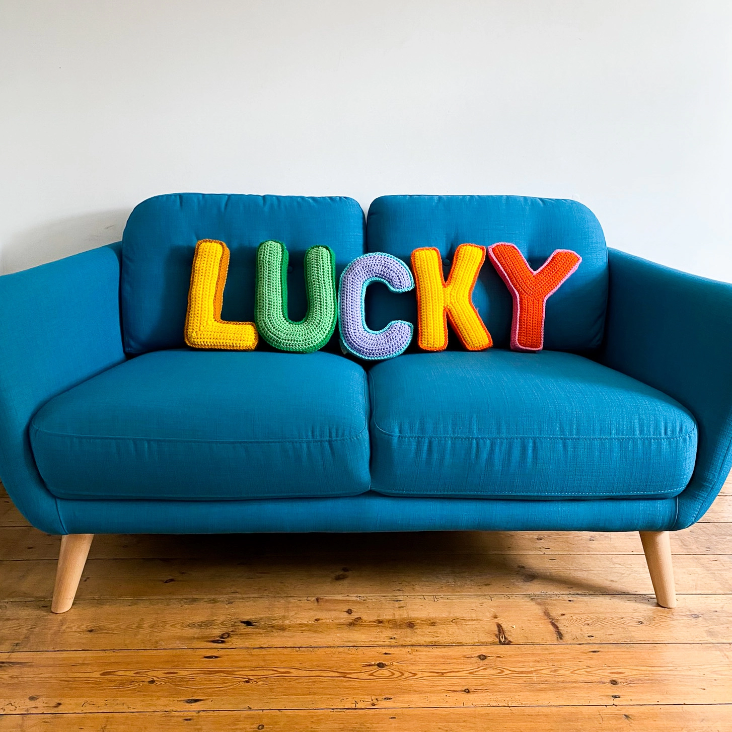 Crochet Letter cushions spelling out LUCKY on a sofa