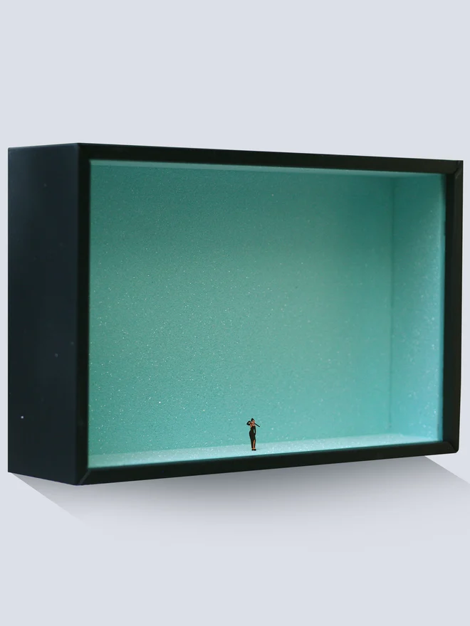 Miniature scene in an artbox showing a tiny Audrey Hepburn as Holly Golightly, against a sparkling backdrop of Tiffany’s duck-egg blue. 