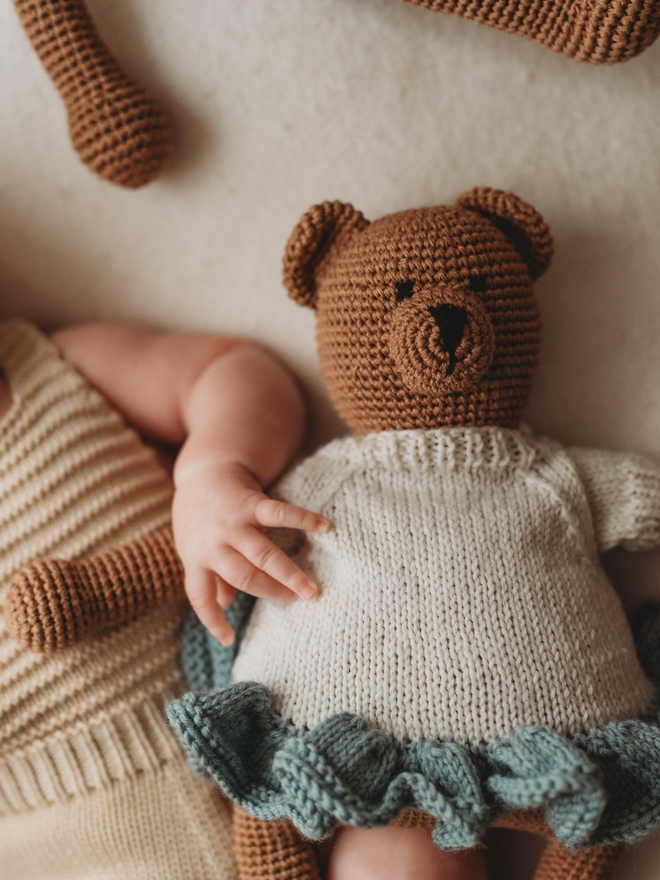 hand crochet brown teddy bear wearing hand knit blue and white dress lifestyle shot