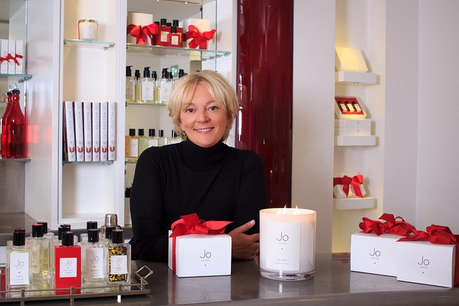 Jo Malone CBE, founder of Jo Loves, sitting behind her products in her shop