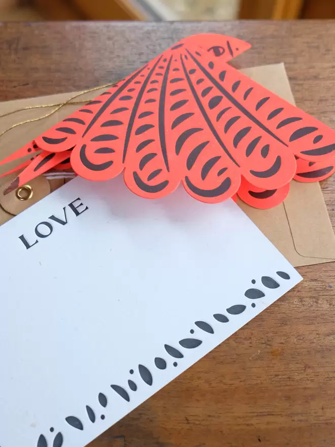 Red folded letterpress bird with 'Love' notecard and string and washer envelope.