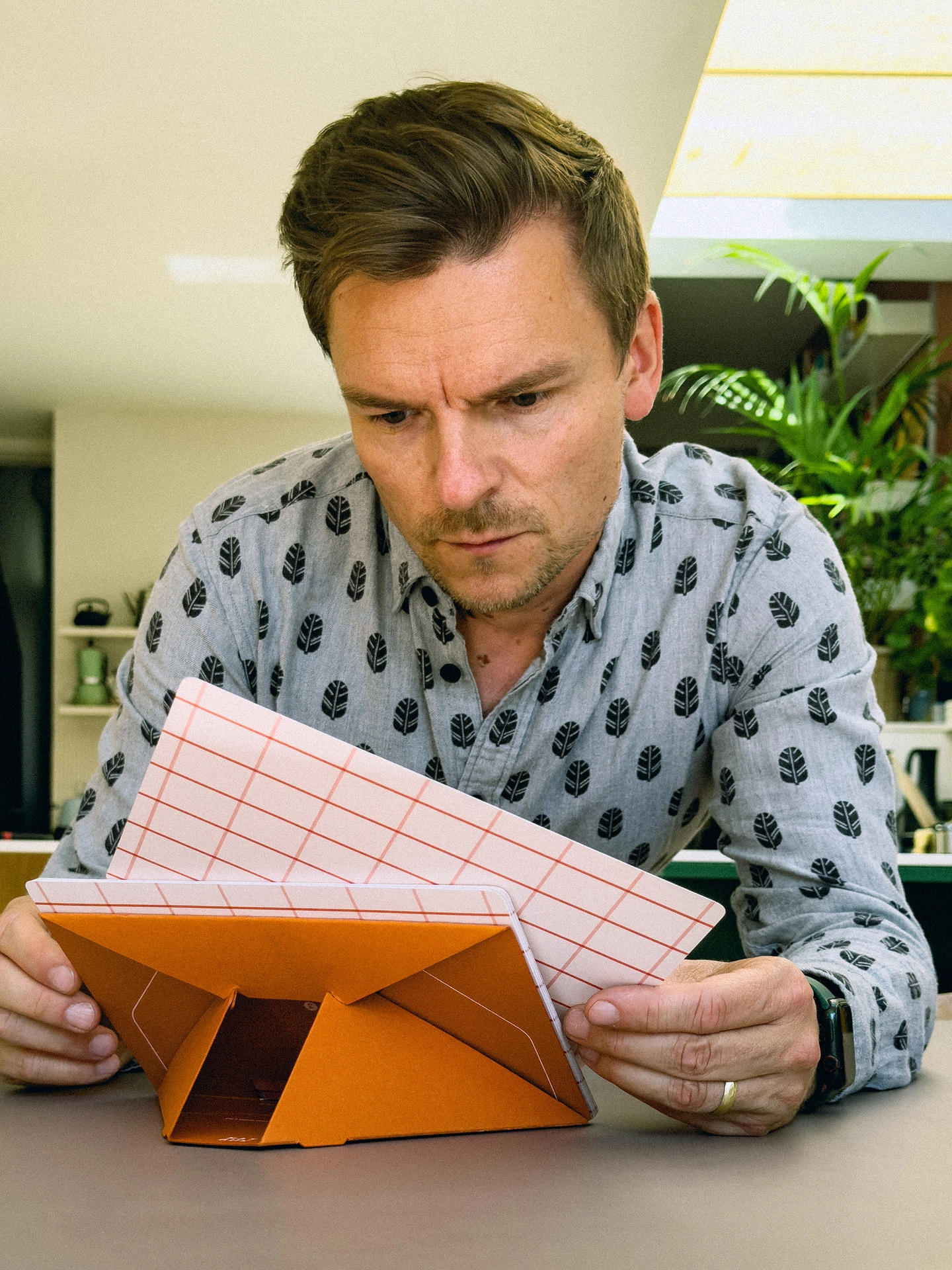 Mat Cuk with an orange Squared desk calendar in hands, blurred room in the background