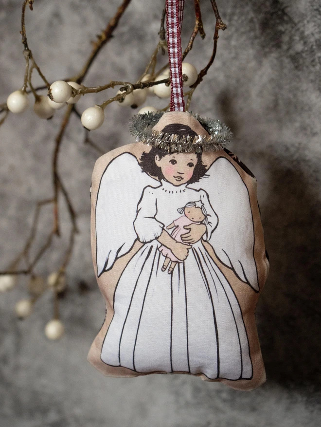 sweet illustrated dark haired angel holding a fairy doll Christmas tree decoration