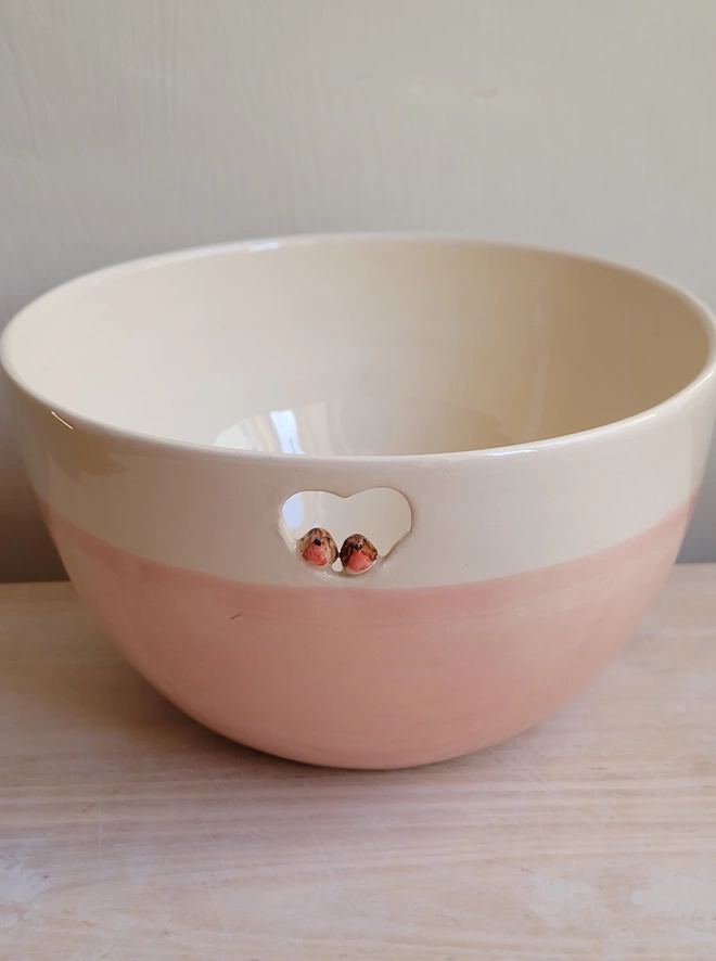 pink ceramic bowl with a cut out heart and two tiny robins perching inside a cut out heart