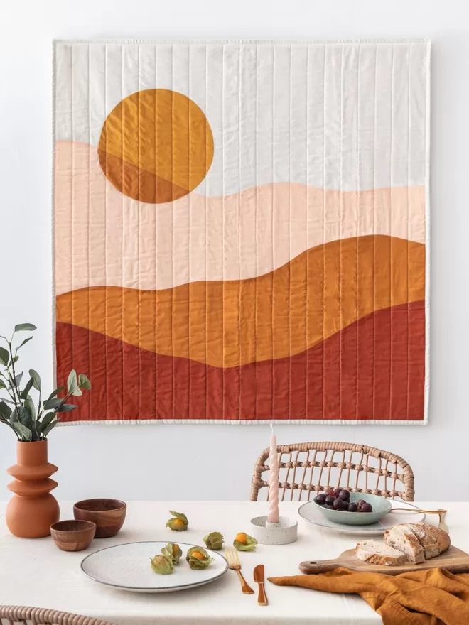 Golden Hour Quilt Hanging Above Table In Dining Room 