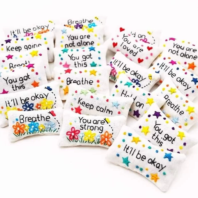 A group of hand embroidery lavender bags stitched with positive and calming phrases and floral decoration