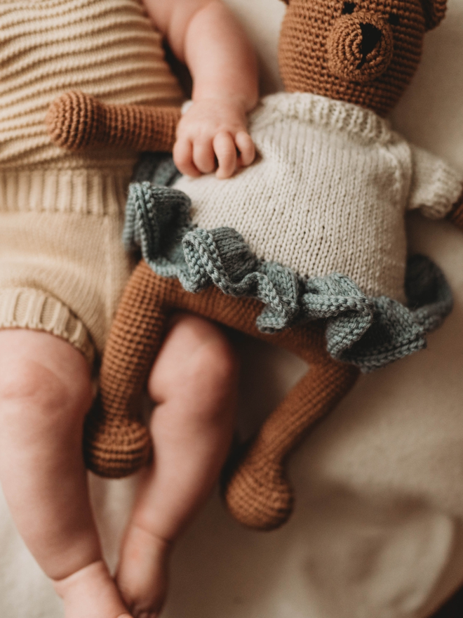 hand crochet brown teddy bear wearing hand knit blue and white dress lifestyle shot