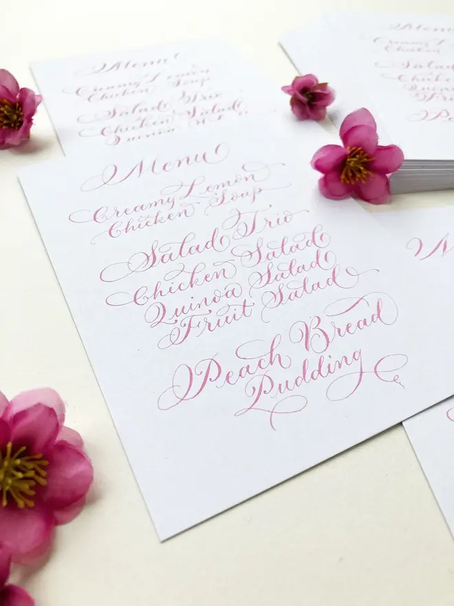 calligraphy wedding menus. white menu with pink calligraphy.