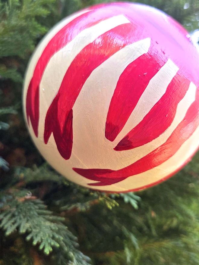 hand painted bauble hanging on a christmas tree, with funny crab legs wearing high heels 