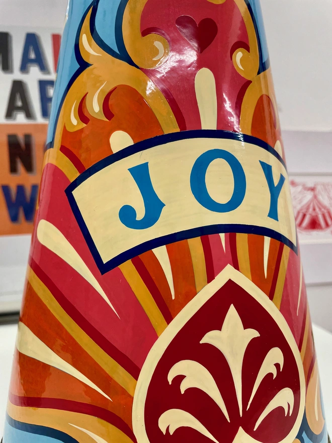 Close up image of the 'joy' jug, featuring the 'joy' banner and a section of the fairground design