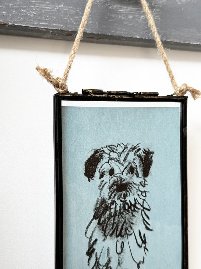 sketchy portrait of dog on blue paper in metal frame
