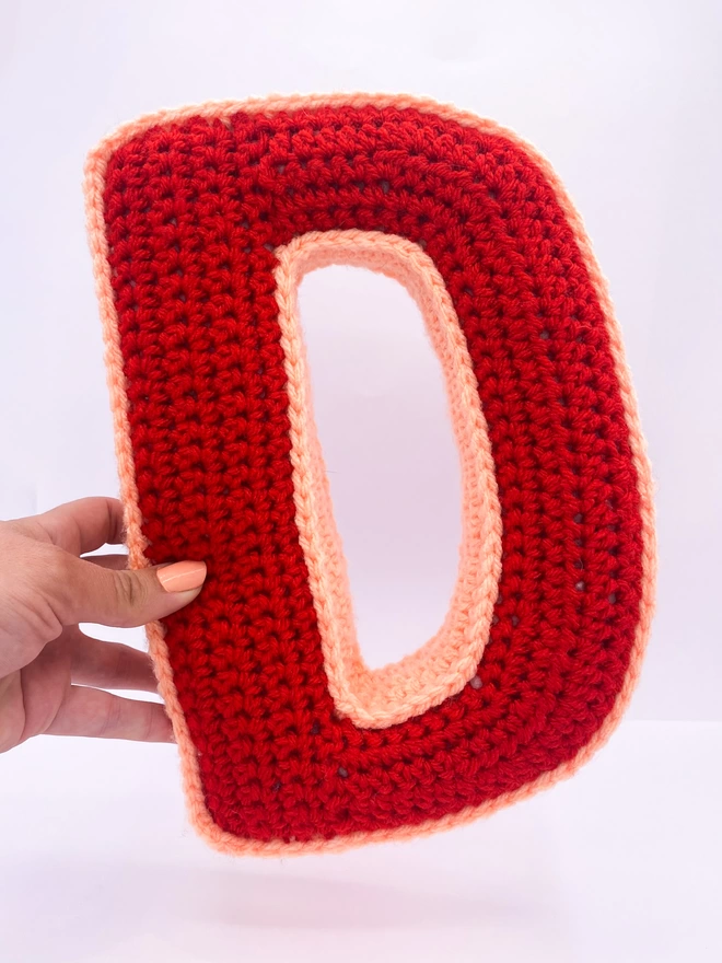 Crocheted D Cushion in Red and Peachy Pink