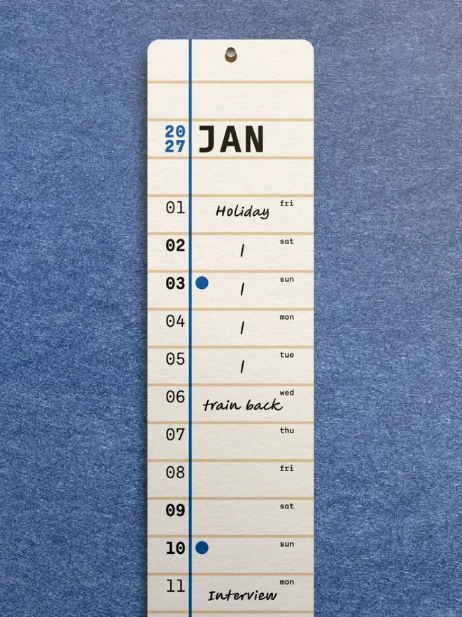 Squared: 2027 Monthly Wall Calendar, on a blue wall. 