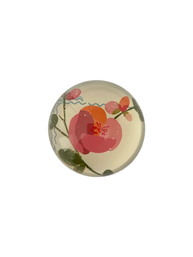 Decoupage Coco Paperweight. Round paperweight with a pink flower design on a white background. 