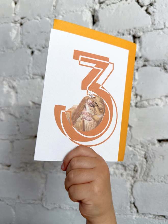 a white card with a big orange number 3 and an illustrated dormouse with a bright yellow envelope