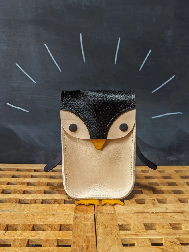 Front view of handmade leather penguin cross- body bag.