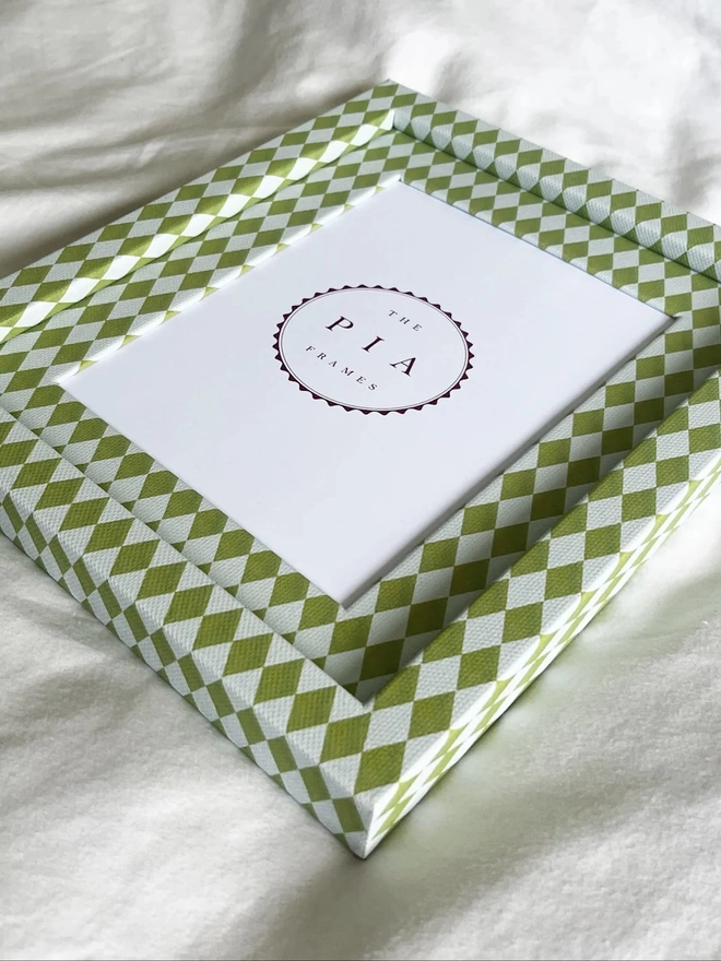 Chartreuse & Frost Harlequin Frame, a colourful patterned frame sitting on a plain white surface. 