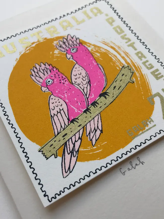 Bird Stamp Card Australian Galah, a white card with a colourful bird design above a white surface. 