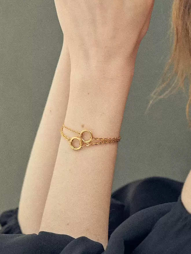 Woman wearing two gold bracelets