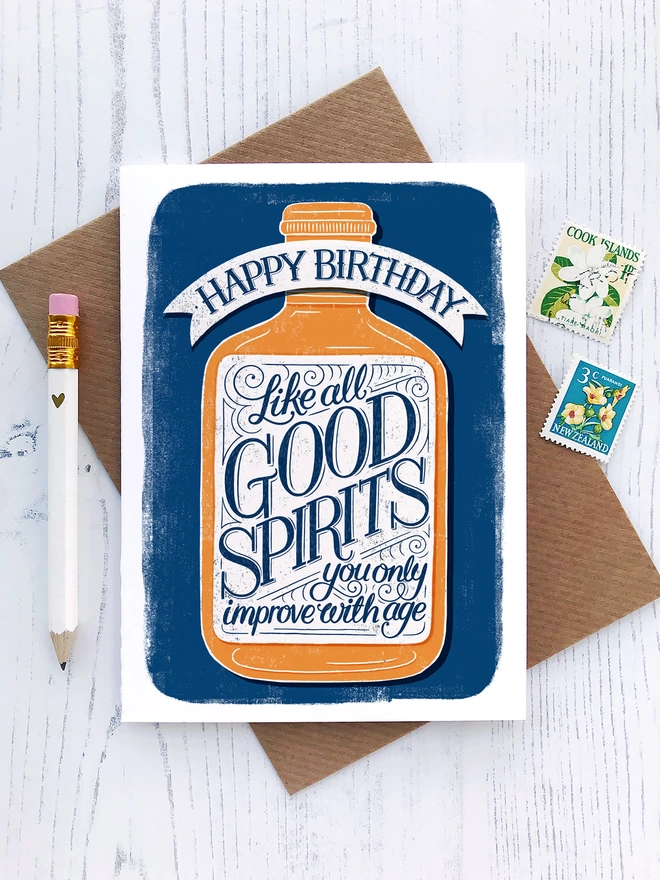 Good spirits birthday card with kraft envelope white pencil and postage stamps