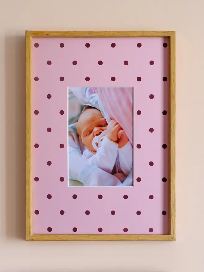 polka dot photo mount. a pink polka dot mount in a frame with a baby photo in the centre.
