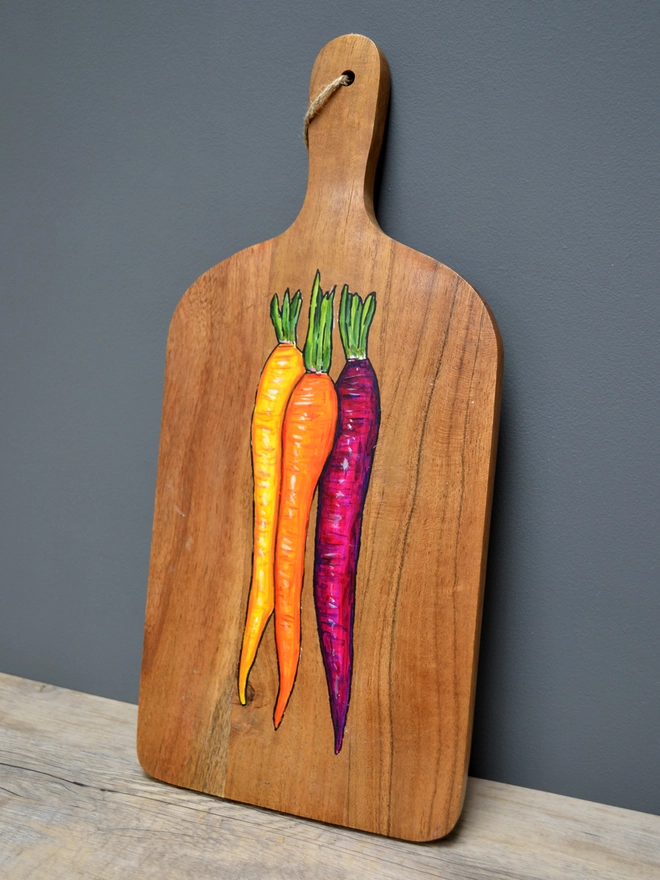 Wooden serving board with a handpainted carrots design