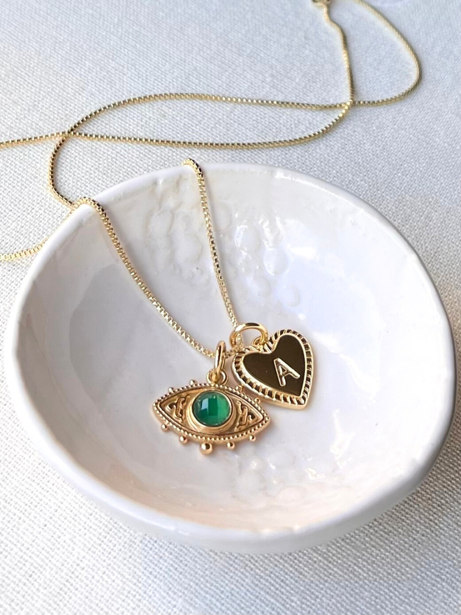 personalised gold evil eye necklace with green stone and gold heart initial charm on a gold box chain necklace