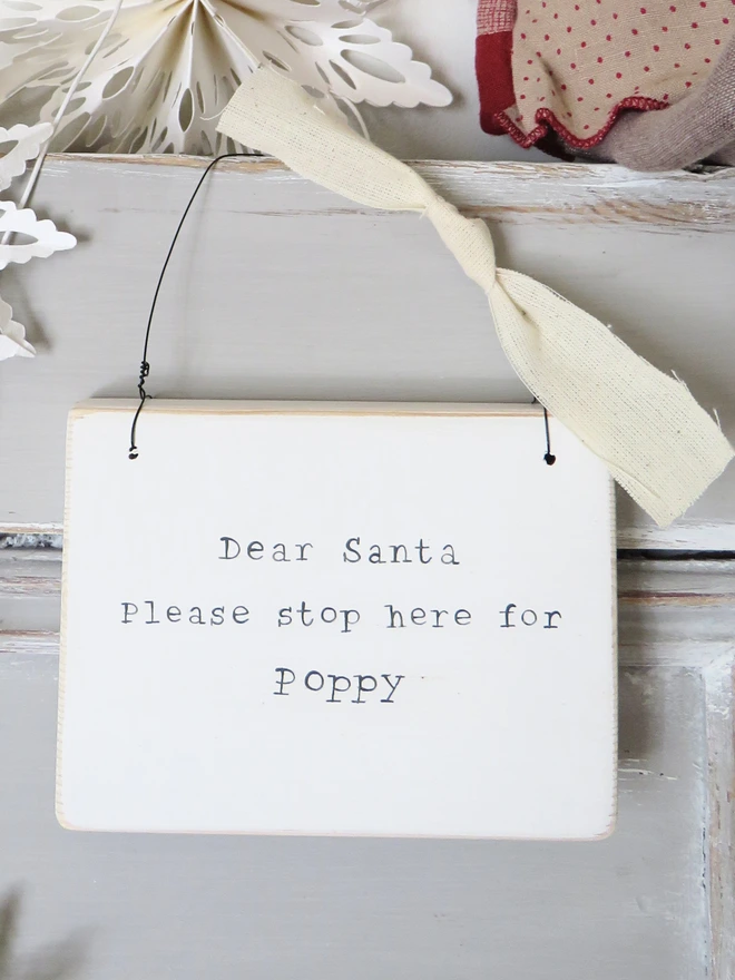 Chalky white painted wooden hanging sign with hand painted personalised Dear Santa message