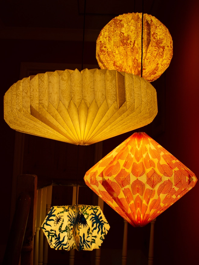 Colourful paper lanterns hang above a wooden staircase with orange walls.