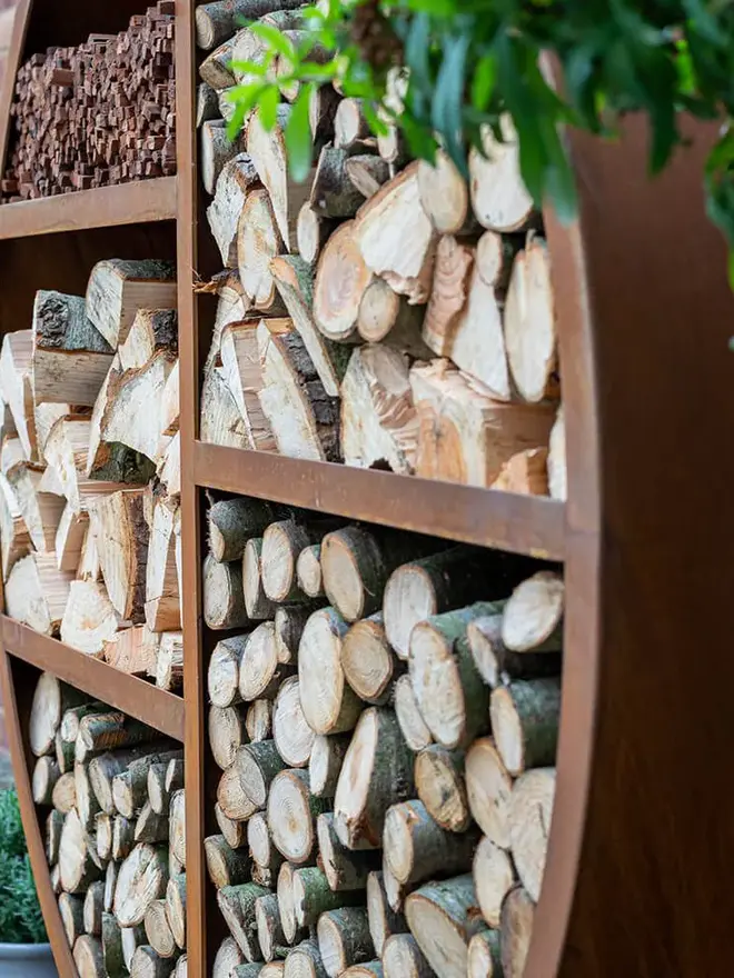Oakham Log Store, log store filled with wood stacked in garden. 