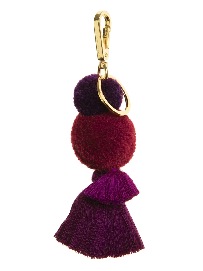 pom pom and tassel keyring bag charm in casis burgundy colours and sturdy gold clip and split ring 