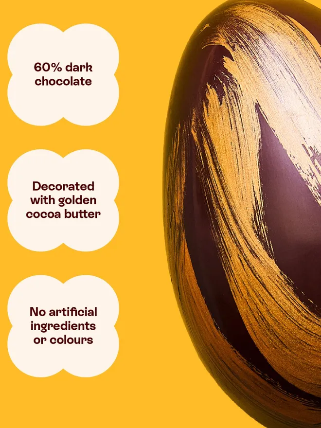 A dark chocolate Easter egg decorated with gold cocoa butter