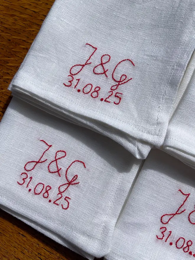 Personalised Hand Embroidered Linen Napkins (Set Of 2), three white napkins with a red personalised message
