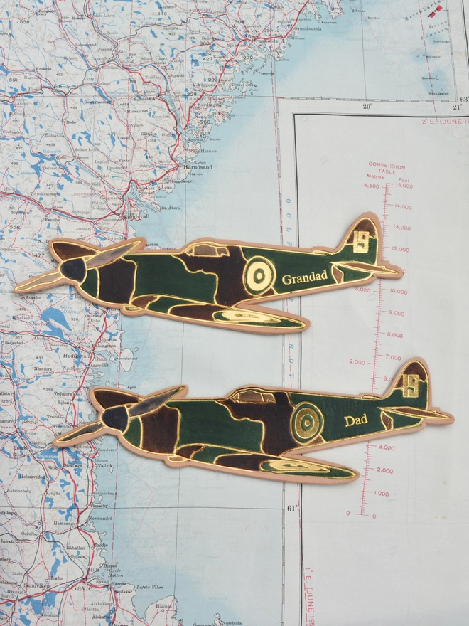 a pair of hand painted leather spitfire bookmarks