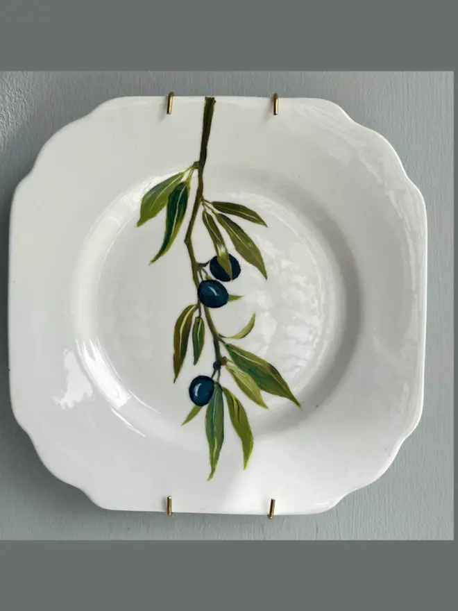 Oil Painted Sloe Berry Spray On A Vintage Tea Plate, hanging on a grey wall. 