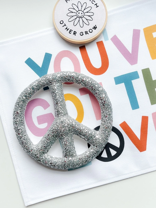 Silver glitter peace sign on a table
