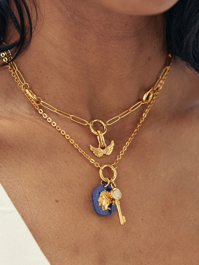 Woman wearing gold necklaces with charms and pendants